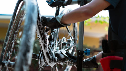 Cyclist Cleaning Bike With Pressure Washer Outdoors 